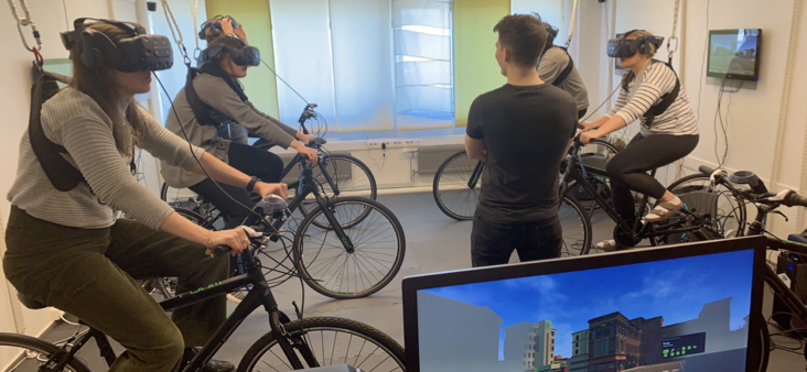 Research participants pedaling on bikes while wearing VR-glasses.